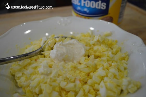 Add mayonnaise to hard-boiled eggs.
