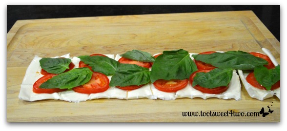 Basil on top of tomatoes and mozzarella cheese for Caprese Roll-ups