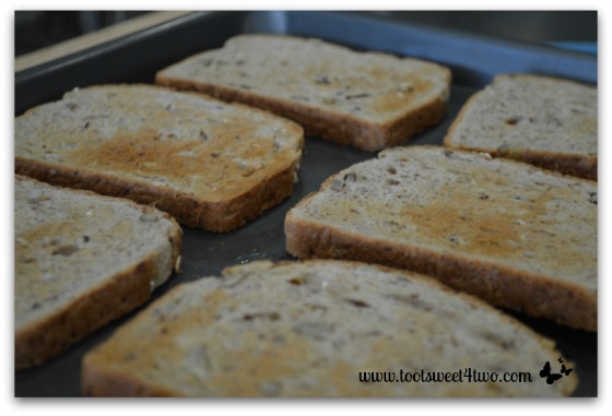 Lightly toasted bread on baking sheet for Chicken and Arugula Open-faced Sandwiches