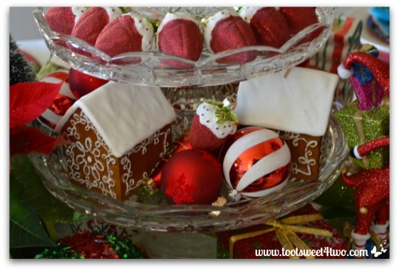 Gingerbread house candles and strawberry ornaments on a 3-tier dessert stand