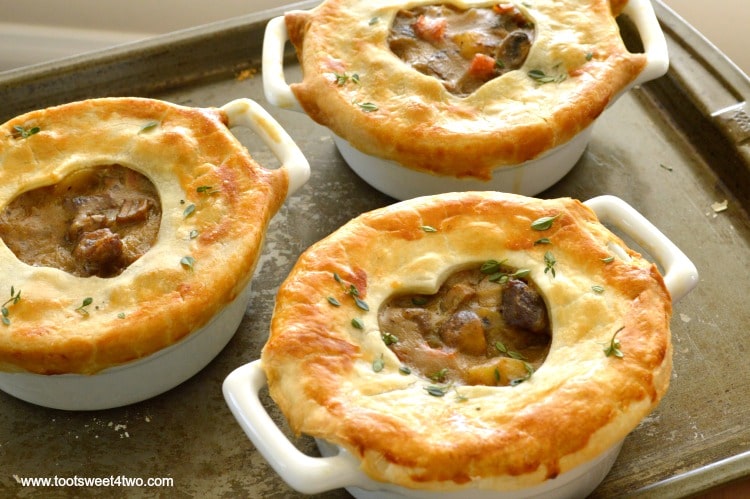 Sweetheart Steak and Potato Pot Pie in individual casserole dishes on a baking sheet.