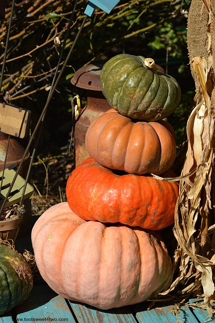 Leaning pumpkins stacked on a porch