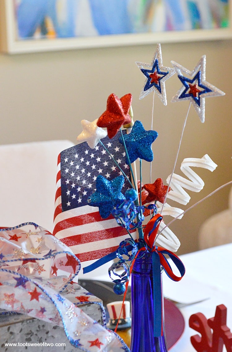 Decorating the table for a 4th of July party? Decked out in red, white and blue, this table scape has a Patriotic centerpiece mimicing fireworks with stars and stripes galore. Check out the decorations and ideas for your Independence Day celebration at www.tootsweet4two.com.