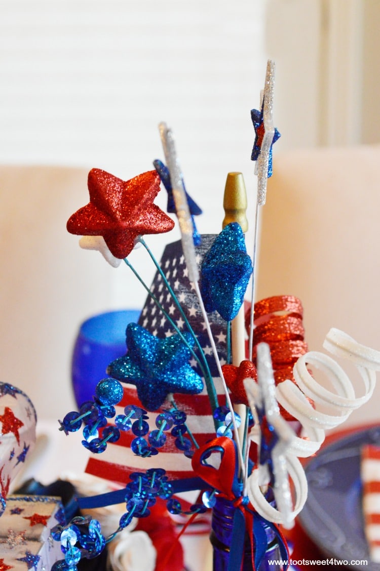 Decorating the table for a 4th of July party? Decked out in red, white and blue, this table scape has a Patriotic centerpiece mimicing fireworks with stars and stripes galore. Check out the decorations and ideas for your Independence Day celebration at www.tootsweet4two.com.