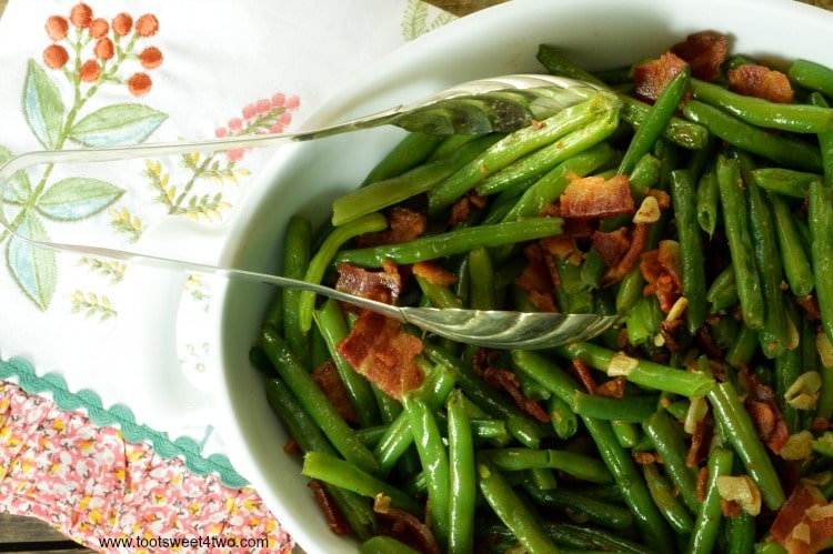 The very best fresh string beans are sauteed in a puddle of bacon grease with slivers of garlic to make a deliciously decadent side dish to accompany any main dish. Bacon Lovers' Garlic-Kissed Fresh String Beans are easy to prepare; have your kids help break the long string beans in half. Can you think of a better way to eat your veggies? | www.tootsweet4two.com
